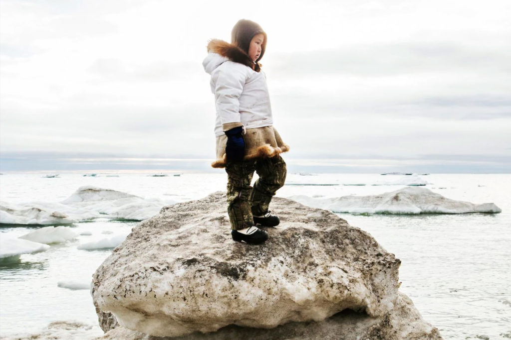 Young girl standing on rocks.