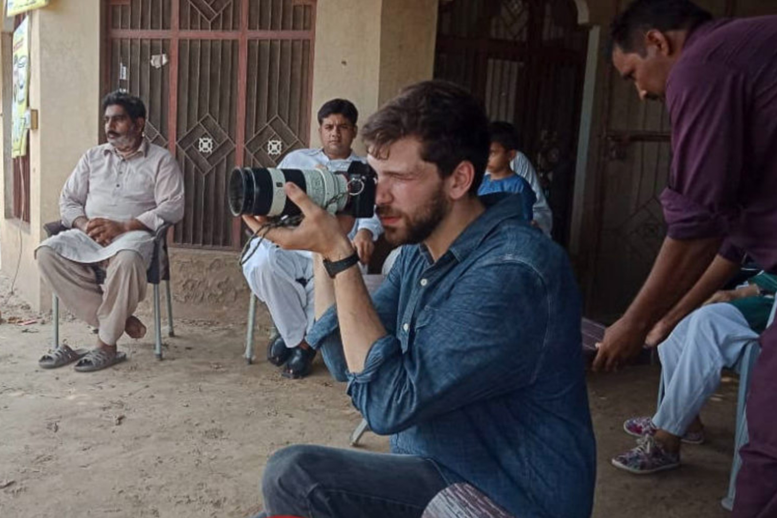 Krahmer with a camera amongst a group of men watching.