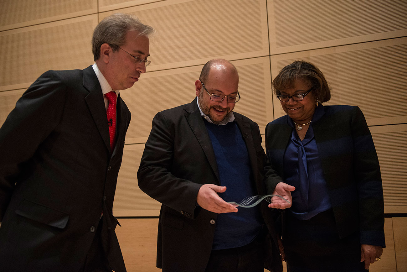 Jason Rezaian, center, observes his award with Roy Gutterman and dean Lorraine Branham.