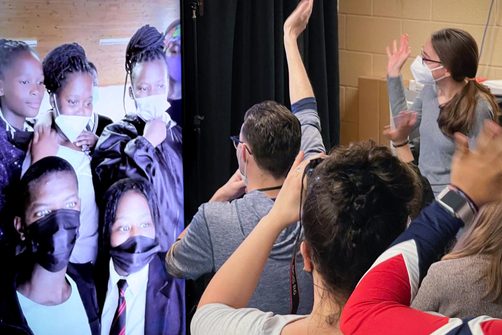 ITS students waving at the South African students through a video portal
