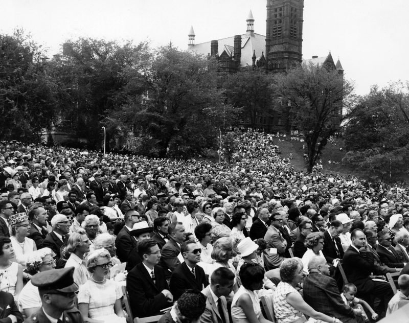 A crowd covers the hill in front of Maxwell Hall to watch President Lyndon B. Johnson dedicate Newhouse 1, Aug. 5, 1964.