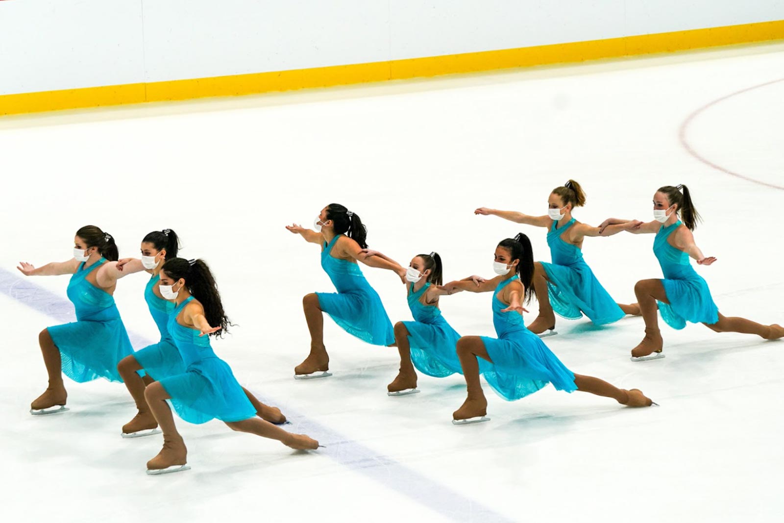 Synchronized figure skaters in green dresses.