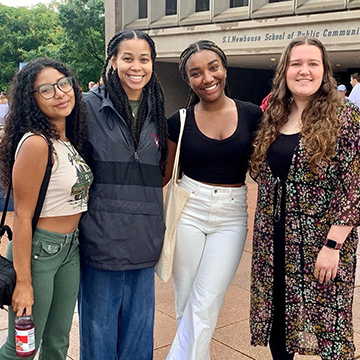 A group of incoming students pose on the Newhouse plaza